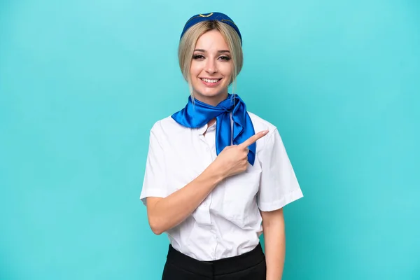 Airplane Blonde Stewardess Woman Isolated Blue Background Pointing Side Present — Zdjęcie stockowe