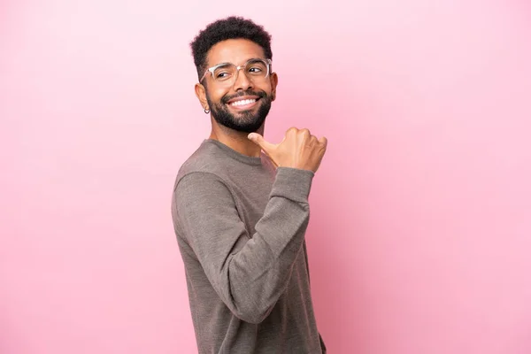 Jovem Brasileiro Isolado Sobre Fundo Rosa Apontando Para Lado Para — Fotografia de Stock