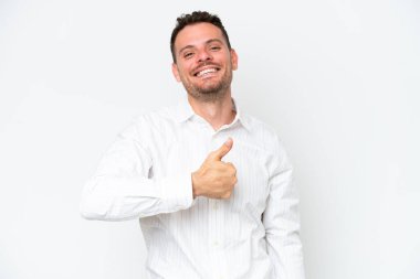 Beyaz arka planda izole edilmiş beyaz, beyaz, yakışıklı genç bir adam baş parmak işareti yapıyor.