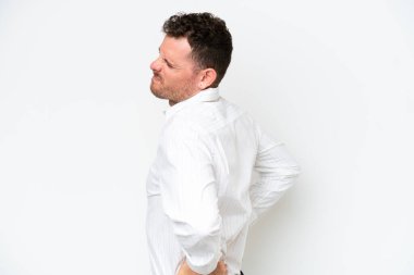 Beyaz arka planda yaşayan beyaz tenli yakışıklı genç adam gayret gösterdiği için sırt ağrısı çekiyor.