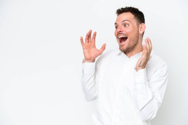 Beyaz arka planda yüzü şaşırmış, beyaz tenli yakışıklı genç bir adam.