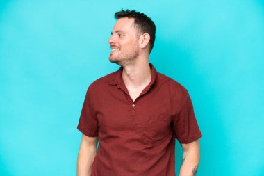 Beyaz tenli yakışıklı adam mavi arka planda izole edilmiş.