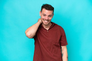 Genç beyaz yakışıklı adam mavi arka planda izole edilmiş gülüyor.