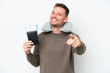 Young caucasian man holding a passport isolated on white background pointing front with happy expression