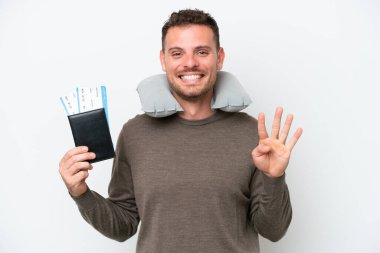 Young caucasian man holding a passport isolated on white background happy and counting four with fingers