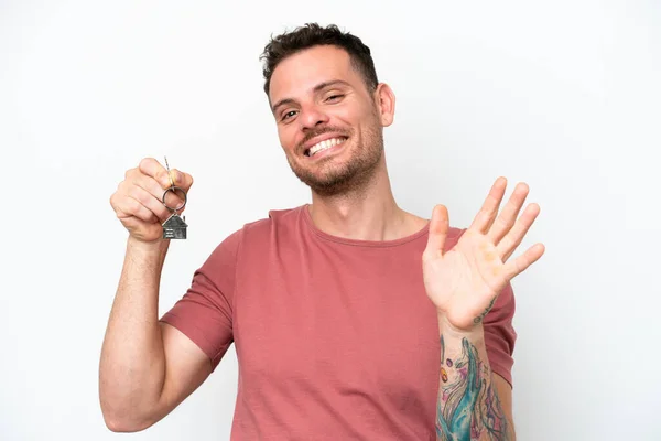 Young Caucasian Man Holding Home Keys Isolated White Background Saluting — Stockfoto