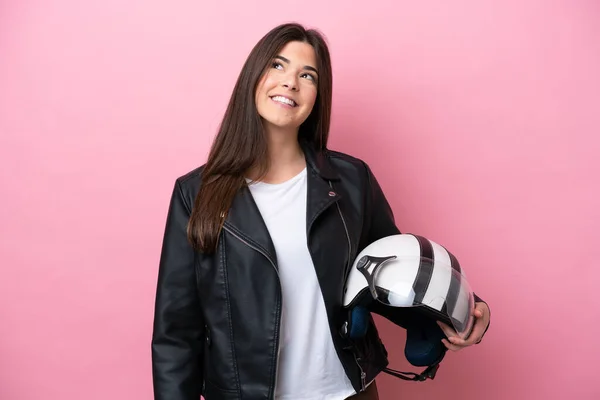 若いですブラジル人女性とともにオートバイヘルメット隔離ピンクの背景思考アイデアながら検索 — ストック写真