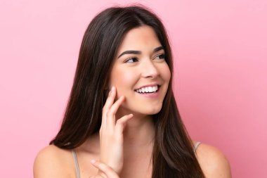 Pembe arka planda izole edilmiş genç Brezilyalı kadın. Portre