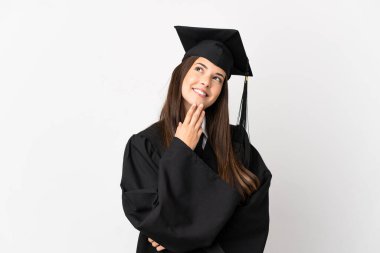 Teenager Brazilian university graduate over isolated white background looking up while smiling