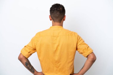 Young caucasian Brazilian man isolated on white background in back position