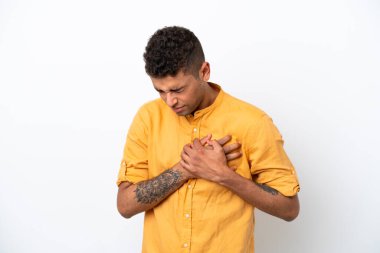 Young caucasian Brazilian man isolated on white background having a pain in the heart