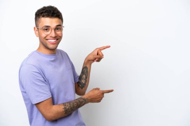 Young caucasian Brazilian man isolated on white background pointing finger to the side and presenting a product