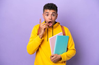Young student Brazilian man isolated on purple background intending to realizes the solution while lifting a finger up