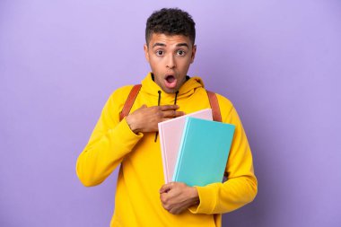 Young student Brazilian man isolated on purple background surprised and shocked while looking right