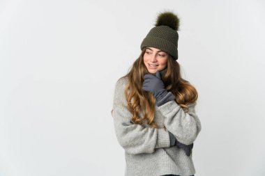 Young caucasian woman with winter hat isolated on white background looking to the side and smiling
