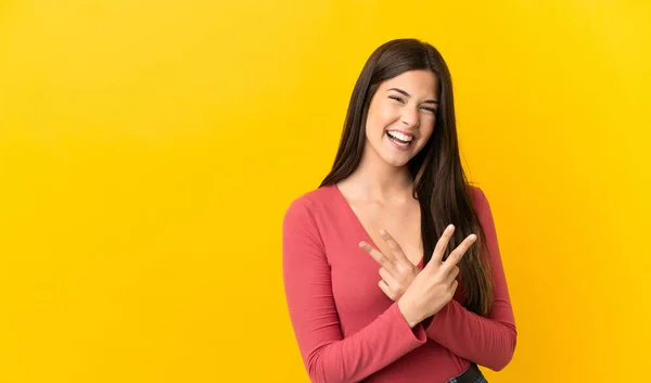 Tiener Braziliaanse Meisje Geïsoleerde Gele Achtergrond Glimlachen Tonen Overwinning Teken — Stockfoto