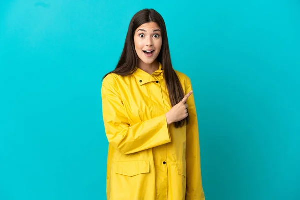Teenager Brazilian Girl Wearing Rainproof Coat Isolated Blue Background Surprised — Fotografia de Stock