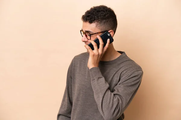 Young Brazilian Man Isolated Beige Background Keeping Conversation Mobile Phone —  Fotos de Stock