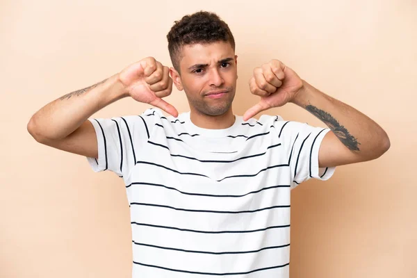 Young Brazilian Man Isolated Beige Background Showing Thumb Two Hands — Stockfoto