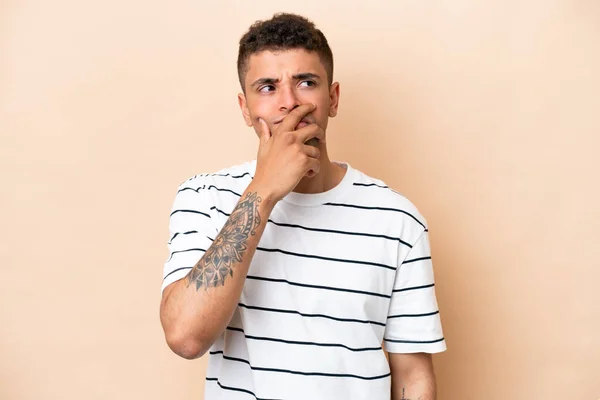 Young Brazilian Man Isolated Beige Background Having Doubts Confuse Face — Stockfoto