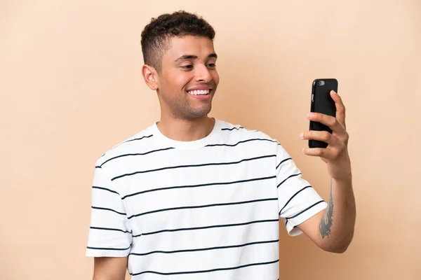 Young Brazilian Man Isolated Beige Background Making Selfie — Zdjęcie stockowe