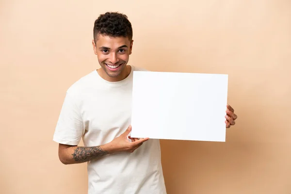 Young Brazilian Man Isolated Beige Background Holding Empty Placard Happy — Φωτογραφία Αρχείου