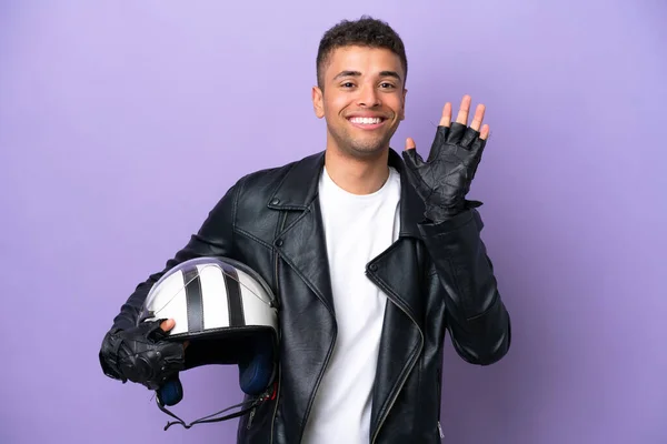 Νεαρός Βραζιλιάνος Άνδρας Κράνος Μοτοσικλέτας Απομονώνονται Μωβ Φόντο Χαιρετισμό Χέρι — Φωτογραφία Αρχείου