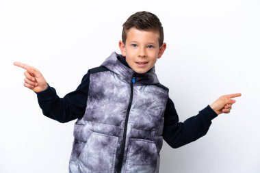 Little boy isolated on white background pointing finger to the laterals and happy