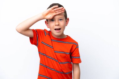Little boy isolated on white background looking far away with hand to look something