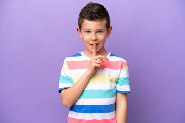 Little boy isolated on purple background showing a sign of silence gesture putting finger in mouth