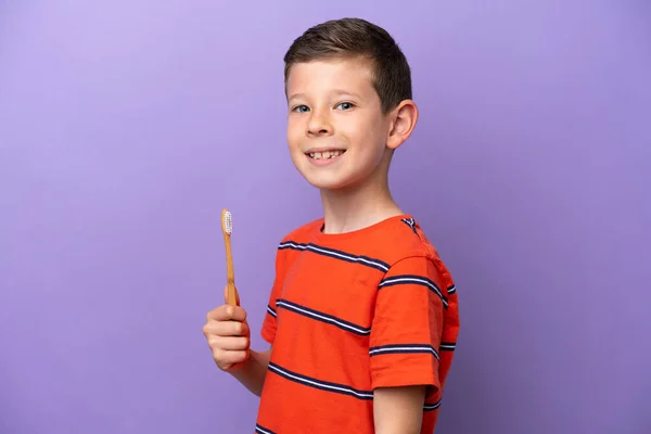 紫色の背景に孤立した小さな男の子の歯をブラッシング多くの笑顔 — ストック写真