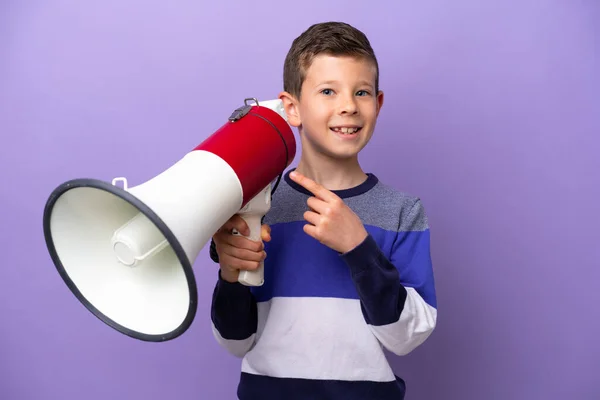 Little Boy Isolated Purple Background Holding Megaphone Pointing Side — Stockfoto