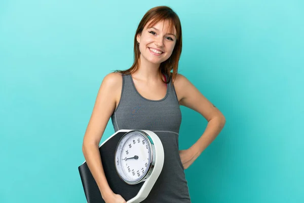 Redhead Girl Isolated Blue Background Arms Hip Holding Weighing Machine — Stok fotoğraf