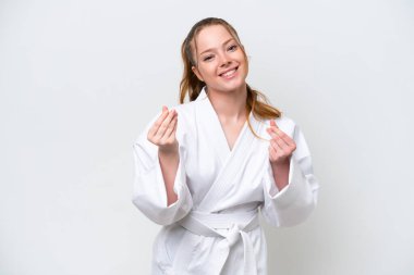 Young caucasian girl doing karate isolated on white background making money gesture