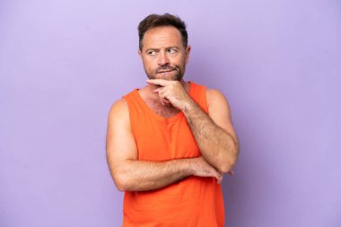 Middle age caucasian man isolated on purple background having doubts and thinking