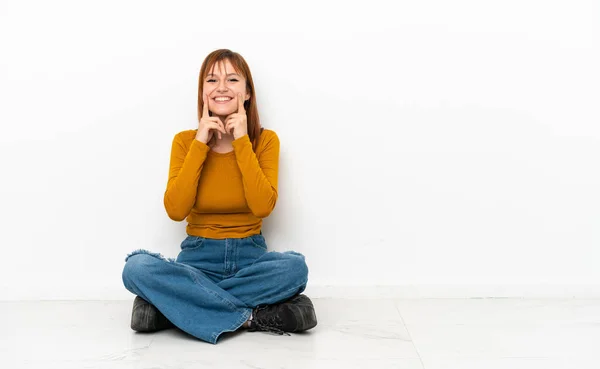 Redhead Girl Sitting Floor Isolated White Background Smiling Happy Pleasant — Stockfoto