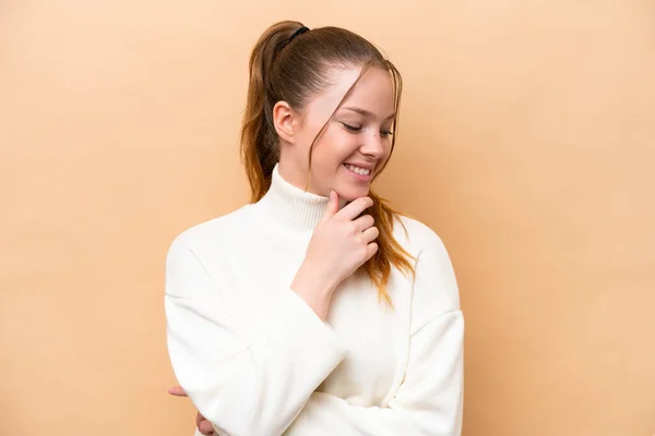 Jovem Caucasiana Isolada Fundo Bege Olhando Para Lado Sorrindo — Fotografia de Stock