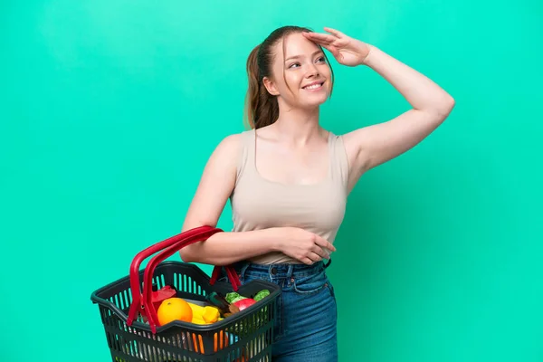 Young Woman Holding Shopping Basket Full Food Isolated Green Background — Φωτογραφία Αρχείου