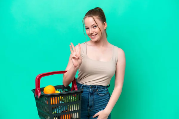Young Woman Holding Shopping Basket Full Food Isolated Green Background — Stock Photo, Image