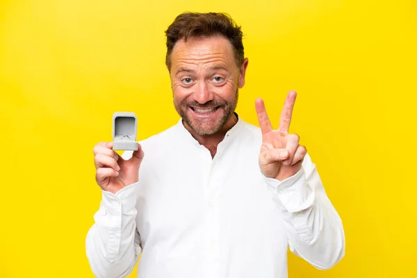 Middle Age Man Holding Engagement Ring Isolated Yellow Background Smiling — Stok fotoğraf