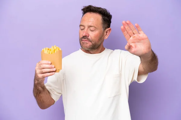 Middle Age Caucasian Man Holding Fried Chips Isolated Purple Bakcground — Stockfoto