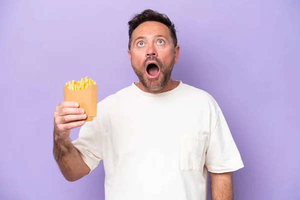 Middle Age Caucasian Man Holding Fried Chips Isolated Purple Bakcground — Zdjęcie stockowe