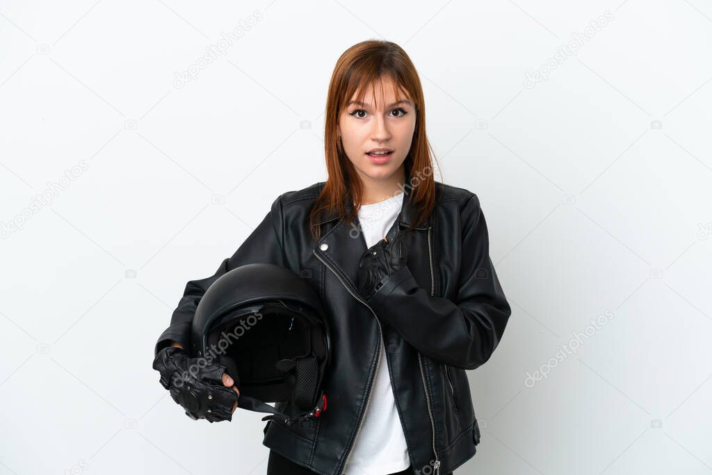 Redhead girl with a motorcycle helmet isolated on white background with surprise facial expression
