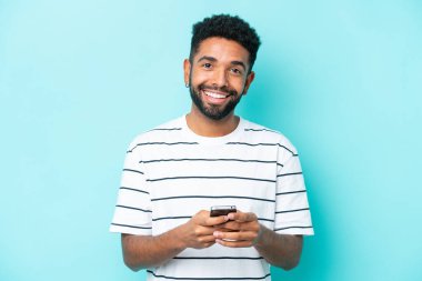 Mavi arka planda kalan Brezilyalı genç adam şaşırdı ve bir mesaj gönderiyor.