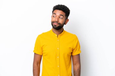 Beyaz arka planda izole edilmiş genç Brezilyalı adam şüpheli hareketler yapıyor.