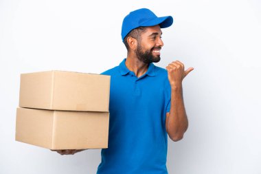 Teslimat yapan Brezilyalı beyaz arka planda izole edilmiş bir adam bir ürün sunmak için kenarı işaret ediyor