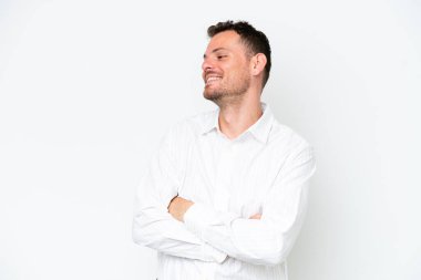 Beyaz arka planda yalnız, mutlu ve gülümseyen beyaz yakışıklı bir adam.