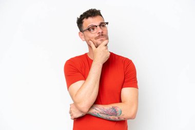 Beyaz arka planda izole edilmiş beyaz tenli yakışıklı bir adam yukarı bakarken bir fikir düşünüyor.