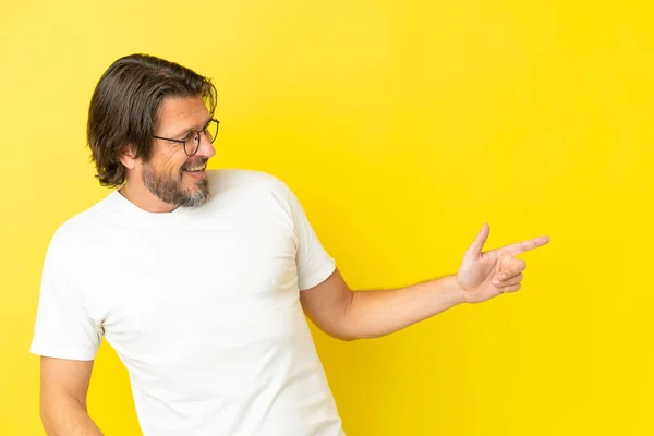 Senior Dutch Man Isolated Yellow Background Pointing Finger Side Presenting — Stockfoto