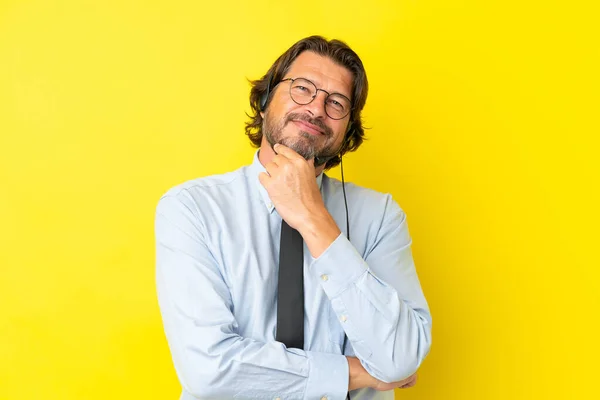 テレマーケターオランダ人男性作業ヘッドセットで隔離された黄色の背景に眼鏡と笑顔 — ストック写真
